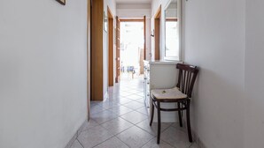 A hallway with a chair, a window, and a door leading to another room. - 4174 Villetta Olmo by Barbarhouse (Porto Cesareo)
