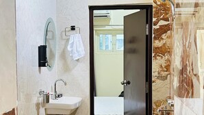 Un baño con lavamanos, espejo y ducha.