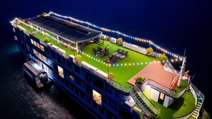 Un gran barco de recreo fluvial con varios niveles, zonas de estar al aire libre y una sección cubierta con un panel solar.