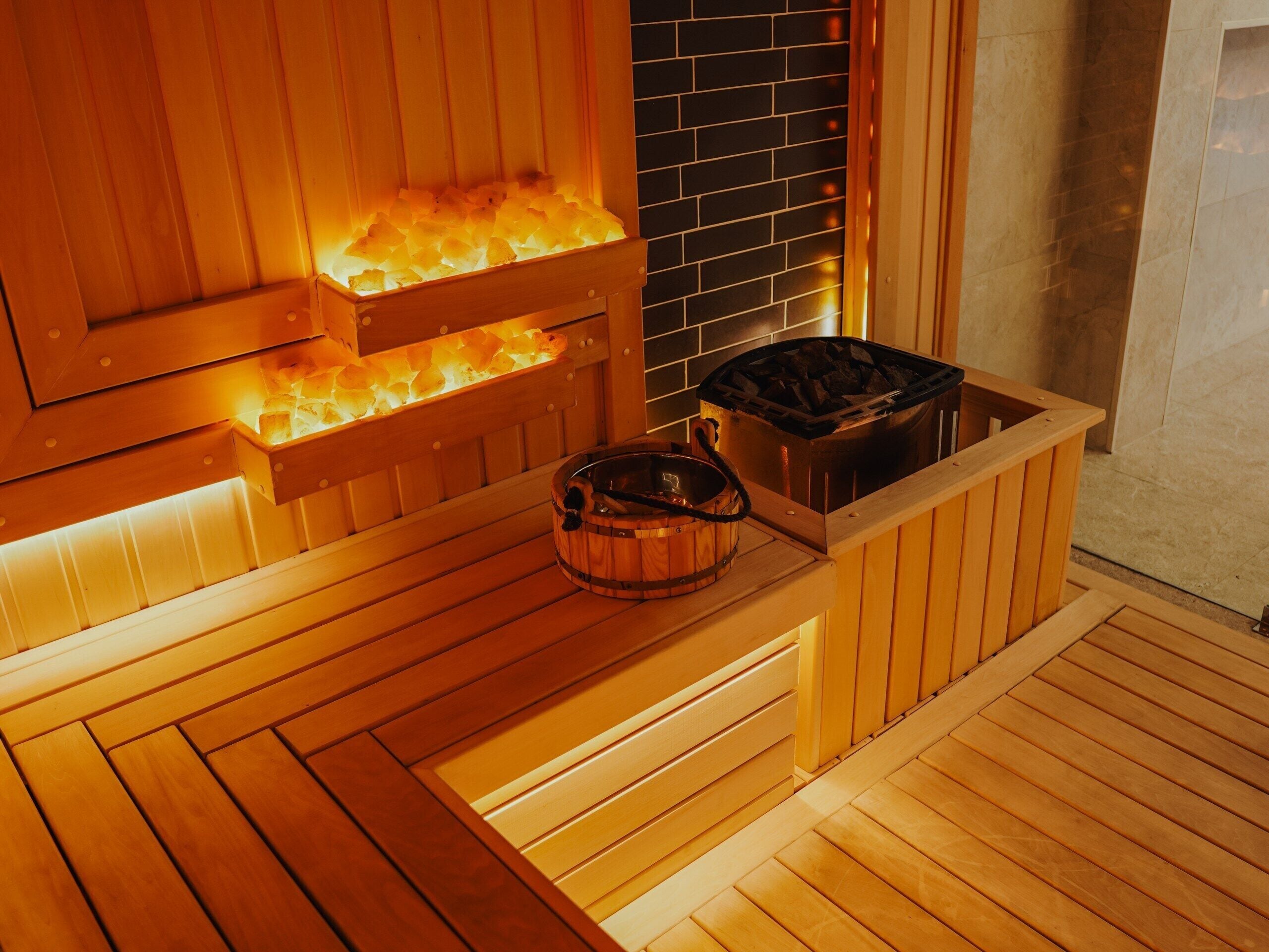 A sauna with wooden benches and a stone wall.