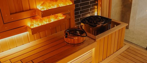 Una sauna con bancos de madera y pared de piedra.