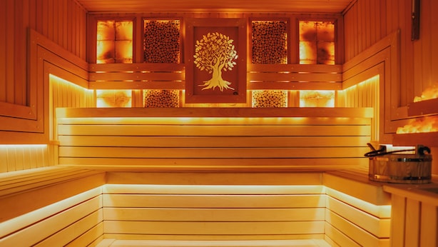 A sauna with wooden benches and a central tree symbol.
