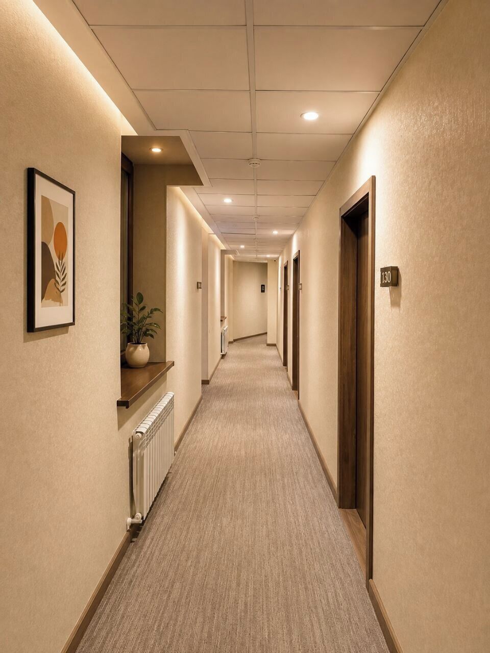 A hotel corridor with a carpeted floor, framed artwork on the walls, a potted plant, and a door with the number 130.
