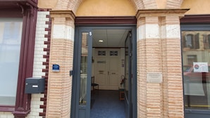 A building entrance with a double door, a sign indicating a 5-star rating, and a sign for a medical practice. - Charmant Gite aux Beaux Volumes, Jardin Privé, Idéal en Familles (Beaumont-de-Lomagne)