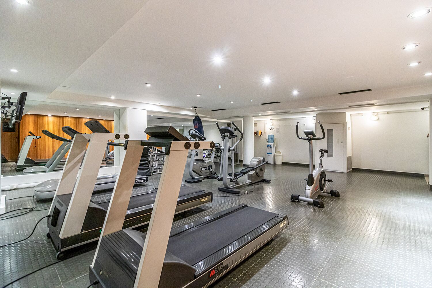 A gym with treadmills, elliptical machines, and weight equipment.