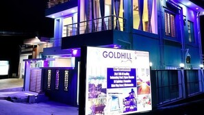 A multi-story building with illuminated balconies and a large sign advertising a bar and restaurant.