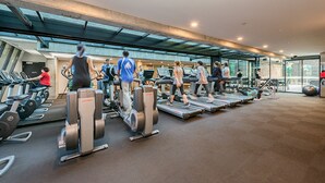 A modern gym with treadmills, stationary bikes, and weight machines. - A 2BR Apt with Harbour Views and FREE Parking (Melbourne)