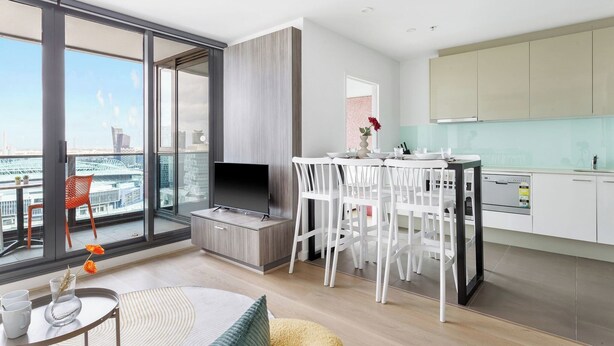 A modern apartment with a balcony, a dining area, and a kitchen. - A 2BR Apt with Harbour Views and FREE Parking (Melbourne)