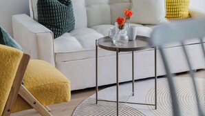A modern living room with a white sofa, green and yellow pillows, a round coffee table, and a yellow armchair. - A 2BR Apt with Harbour Views and FREE Parking (Melbourne)