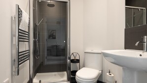 A modern bathroom with a glass-enclosed shower, a white toilet, and a large sink. - Modern & Cosy 1 Bedroom Apartment in York (York)