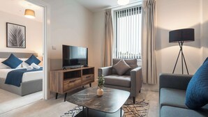 A modern living room with a sofa, a coffee table, a TV, and a lamp. - Modern & Cosy 1 Bedroom Apartment in York (York)