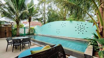 Alberca al aire libre y camastros