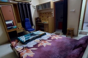 A bedroom with a bed, a desk, a chair, and a wardrobe. - Hyderabad Serenity Retreat - 3 Bdrm Apartment (Hyderabad)