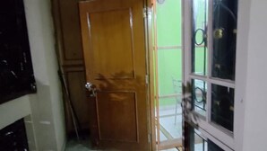 A room with a wooden door, a glass door, and a green wall. - Hyderabad Serenity Retreat - 3 Bdrm Apartment (Hyderabad)