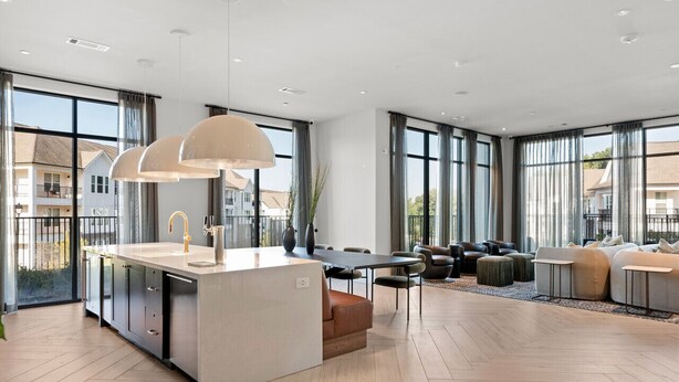 A modern kitchen with a central island, large windows, and a dining area with sofas and chairs. - Charming, New Apt | Pool | Long Stays (Athens)