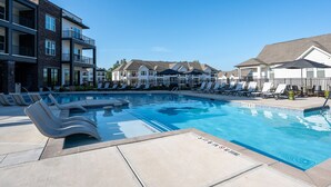 A swimming pool with lounge chairs and a poolside area. - Charming, New Apt | Pool | Long Stays (Athens)