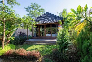 A traditional pavilion with a tiled roof, surrounded by lush greenery and a small garden area. - Lembah Wanna (Banjarangkan)