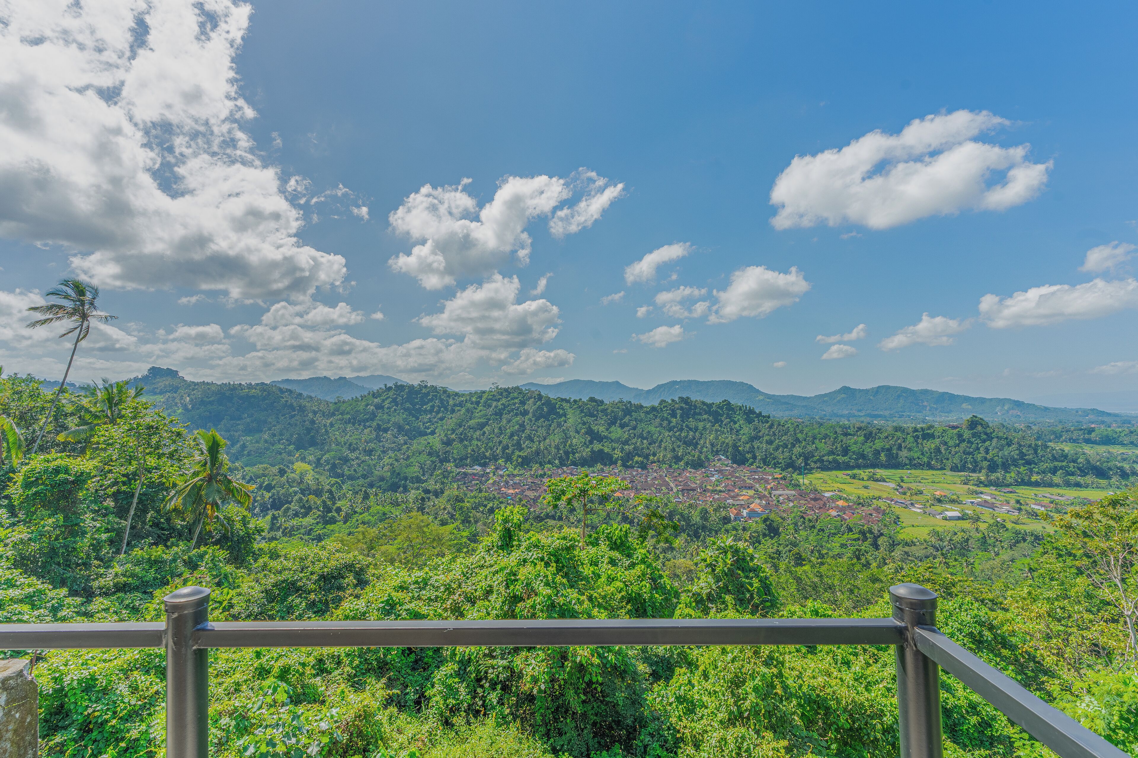 A lush green landscape with a clear sky and distant mountains.