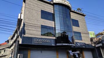Un edifici amb Zara's Arcade, Monsoon Salon i Xcel Salon a la planta baixa.