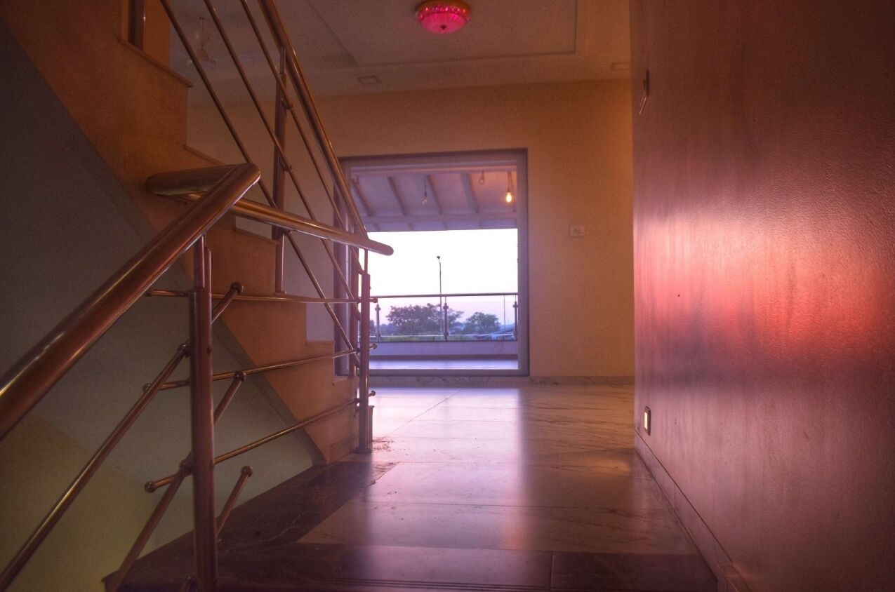 A staircase leading to a balcony with a view of the sky.
