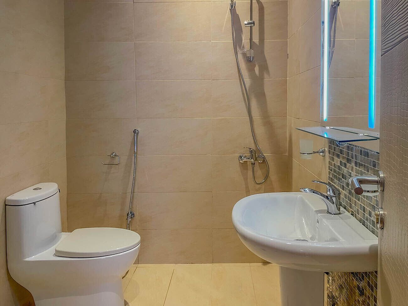 A bathroom with a toilet, a shower, and a sink.