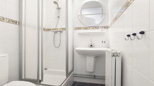 A bathroom with a shower, a sink, and a toilet.