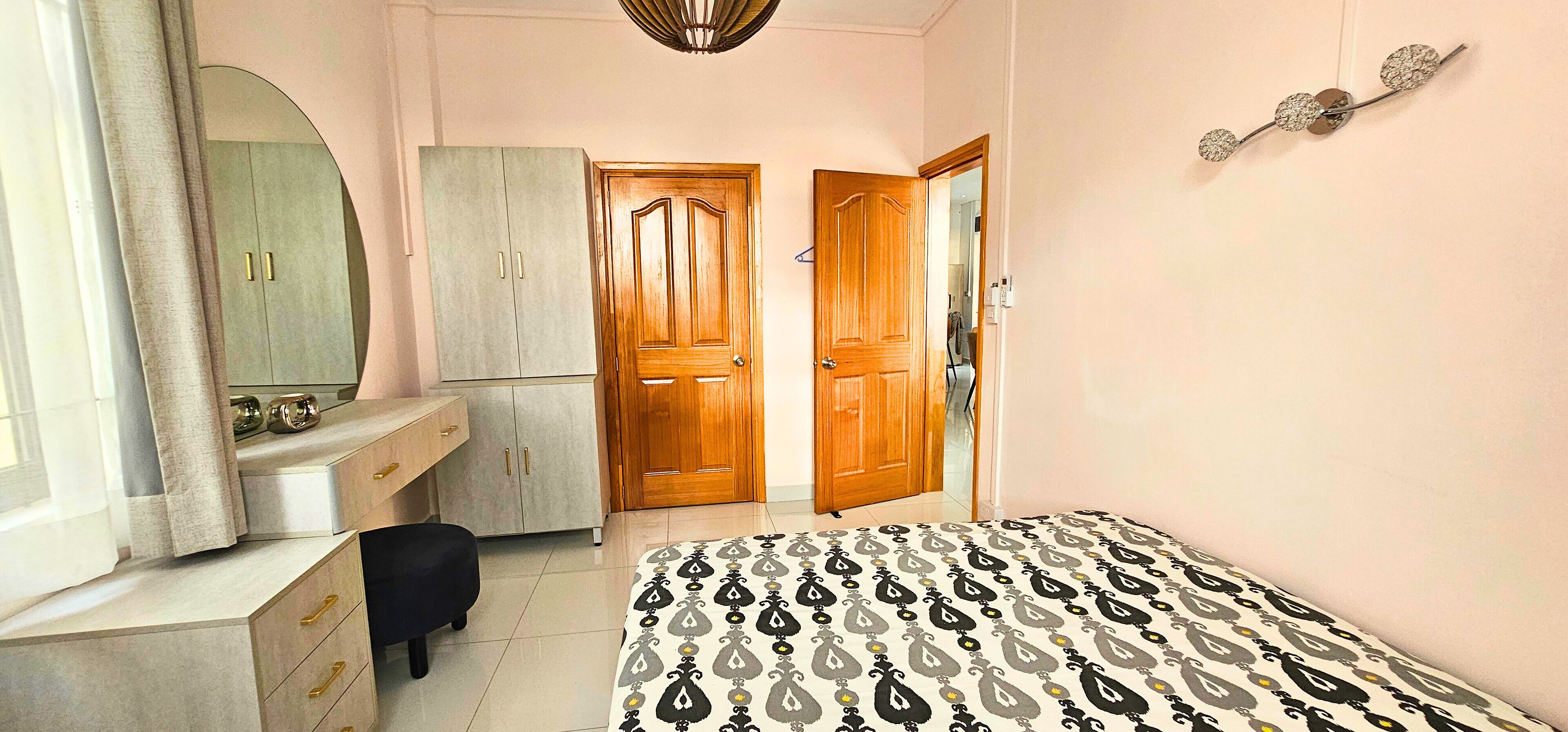 A bedroom with a bed, a wardrobe, a mirror, and a door.