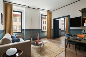 Un salon moderne comprenant un canapé, une table basse et un coin repas avec une chaise et une petite table.