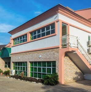 A two-story building with a flat roof, large windows, and a staircase leading to an upper level. - Bliss World Resorts & Hotels (Akure)