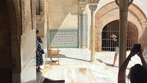 An interior courtyard with intricate architectural details, a bench, and a person taking a photo. - Casa del Patio PdV (El Pinar)