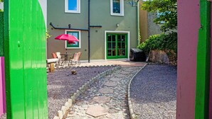 A house with a stone pathway leading to a patio with a table and chairs. - Dingle Town Holiday Home (Dingle)