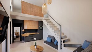 Ein modernes Interieur mit Treppe, einer Küche und einer Sitzecke.