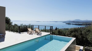 Ein moderner Infinity-Pool mit freiem Blick auf das Meer und die Berge.