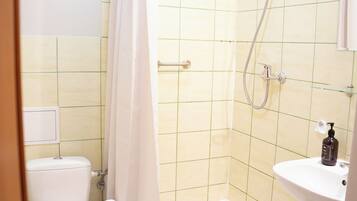 A bathroom with a shower, toilet, and sink.