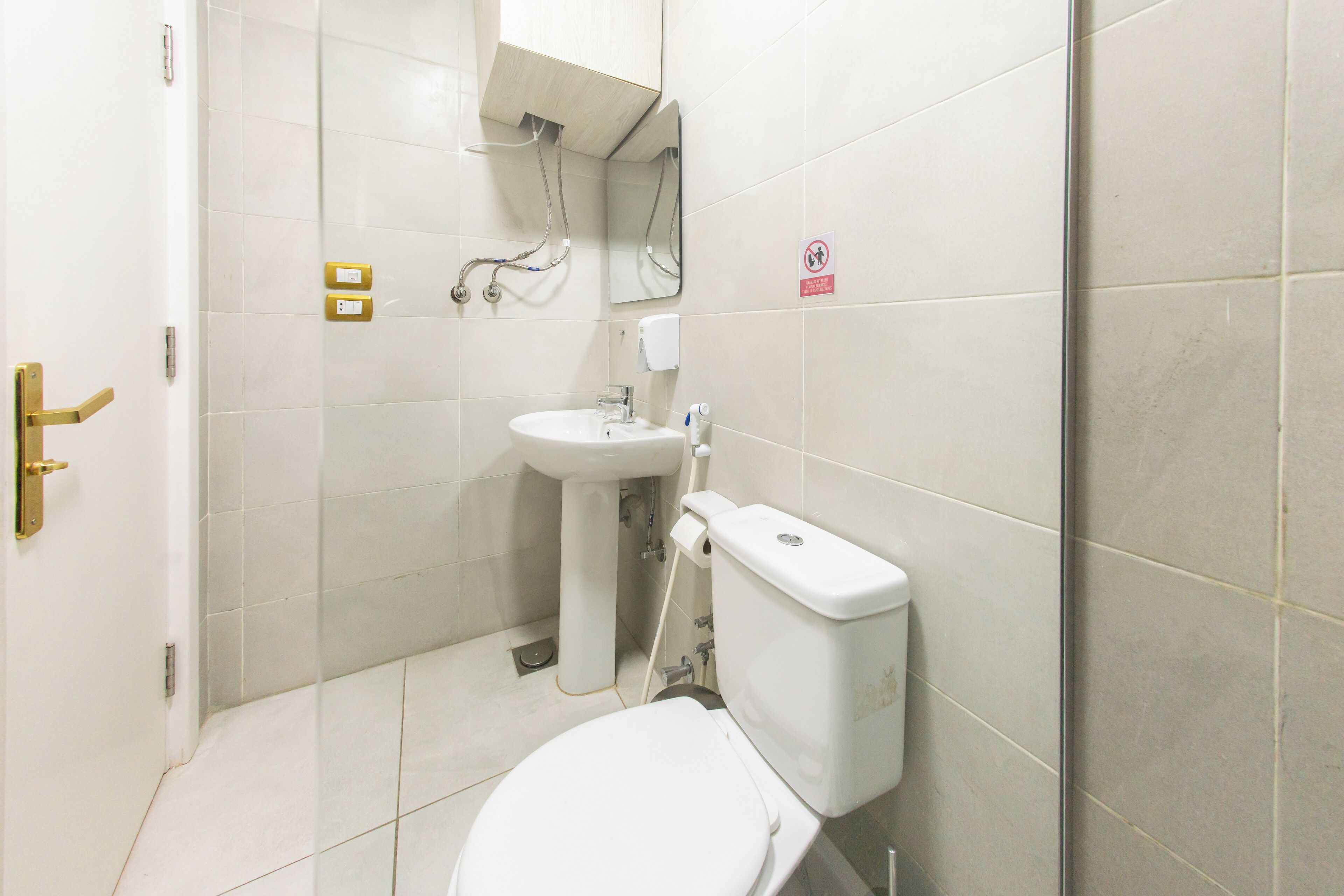 A small, clean bathroom with a toilet, sink, and shower.