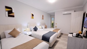 Ein Hotelzimmer mit zwei Betten, einem Fernseher und einer Minibar.