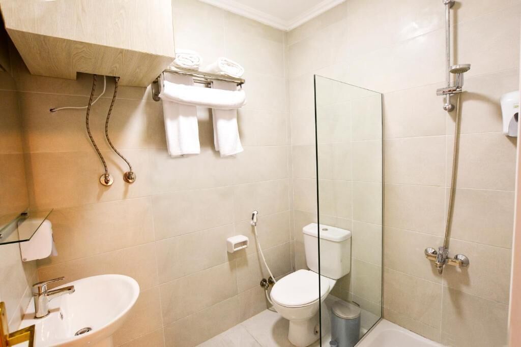 Un baño moderno con cabina de ducha de vidrio, inodoro y lavamanos.