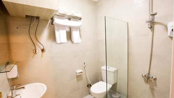Un baño moderno con cabina de ducha de vidrio, inodoro y lavamanos.