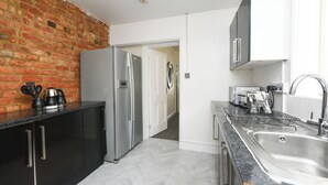 A kitchen with a brick wall, stainless steel appliances, and a modern design.
