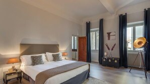A bedroom with a large bed, a nightstand, a dresser, and a window with curtains. - Stunning Holiday Apartment in the Heart of Florence (Firenze)