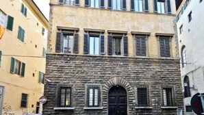 A building with a stone facade, multiple windows with shutters, and a central arched door. - Stunning Holiday Apartment in the Heart of Florence (Firenze)
