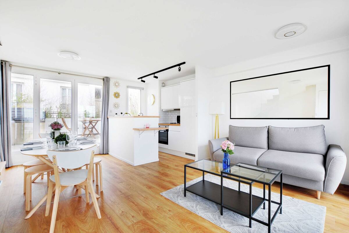 Un salon moderne avec un canapé, une table basse et un coin repas.