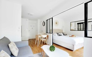 A modern, minimalist bedroom with a bed, a desk, and a sofa. - Résidence Paris Rochechouart (Paris)