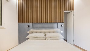 A bedroom with a bed, a headboard with vertical wooden slats, and a grey accent wall. - 4147 Villa Daversa by Barbarhouse (Manduria)