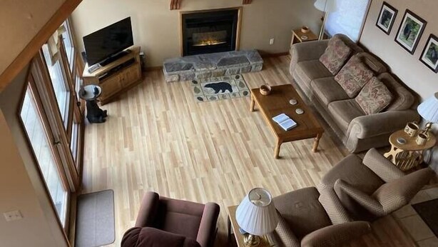 Een gezellige woonkamer met een open haard, een televisie en een stenen haardmantel.