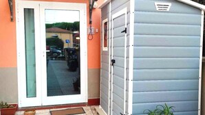 Um edifício com porta de vidro e um pequeno galpão.