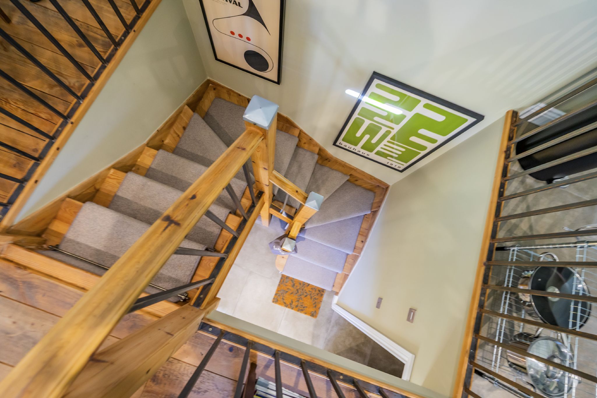 A wooden staircase with a handrail leading to a landing.
