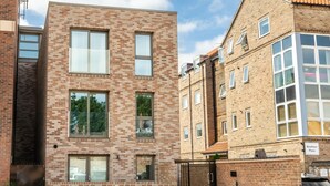 A multi-story building with brick facade, large windows, and a gated entrance. - Bootham Row 8: A Cozy City-Centre Retreat in York (York)