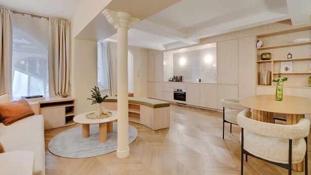 Una sala de estar moderna con un sofá, una mesa de centro y un comedor con sillas.