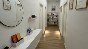 A hallway with a white console table, a mirror, and framed artwork on the walls. - Center Rooms La Spezia  (La Spezia)
